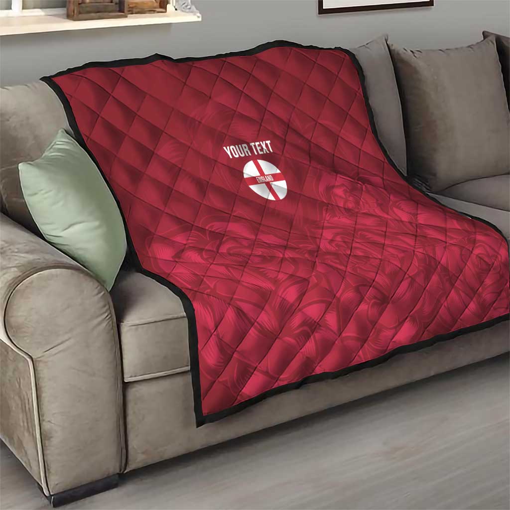 Red quilt with diamond stitching and custom text over England crest emblem on sofa