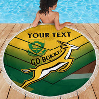 Round beach blanket with fringe, green and gold South Africa rugby “Go Bokke!” graphic