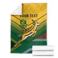 South Africa rugby blanket with Go Bokke logo, yellow-green stripes, with folded towels