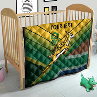 Custom rugby quilt on crib in green-yellow-blue tones with rugby player emblem and “YOUR TEXT”