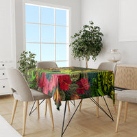 Tablecloth on dining table with bright green tropical pattern, red blooms, and dark details