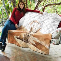 Algerian quilt blanket draped on seating with white and tan diamond quilting and fox emblem
