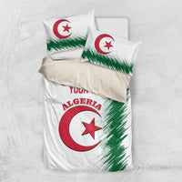 White bedding set flatlay: duvet with Algeria emblem and two matching pillowcases, green streaks
