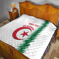 White quilt on bed showing Algeria logo, green diagonal stripe, red “YOUR TEXT”