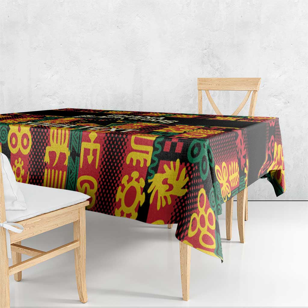 Black tablecloth with multicolor Adinkra pattern across table and bench edge