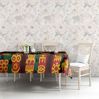 Black tablecloth with colorful Adinkra motifs on dining table