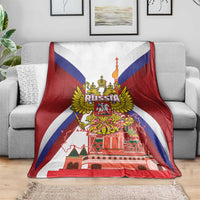 Red blanket with Russia coat of arms and St Basil cathedral print, laid across couch