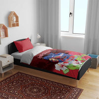 Red duvet cover with mountain crest and large white flowers, set on bed with two pillows