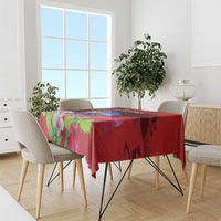 Red patterned tablecloth draped over a dining table with pink and green floral print