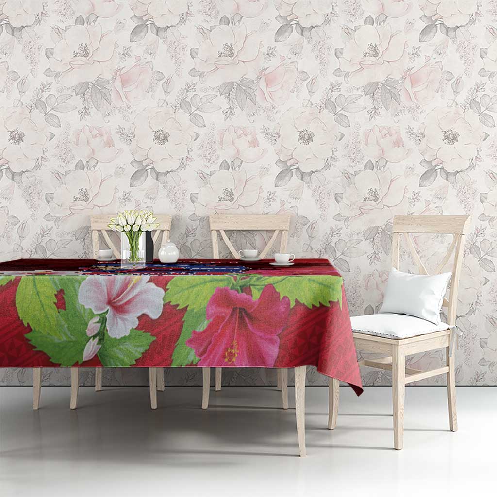 Red tablecloth with oversized hibiscus flowers and green leaves on dining table