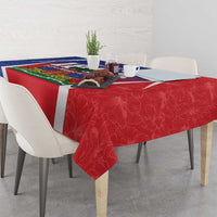 Red patterned tablecloth with white border and blue-and-green center Haiti design