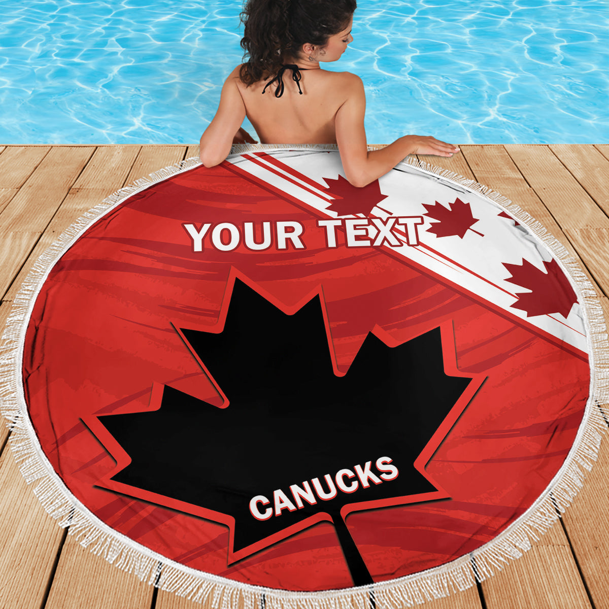 Red circular beach blanket with fringe, 'YOUR TEXT' and Canucks maple leaf, deck view