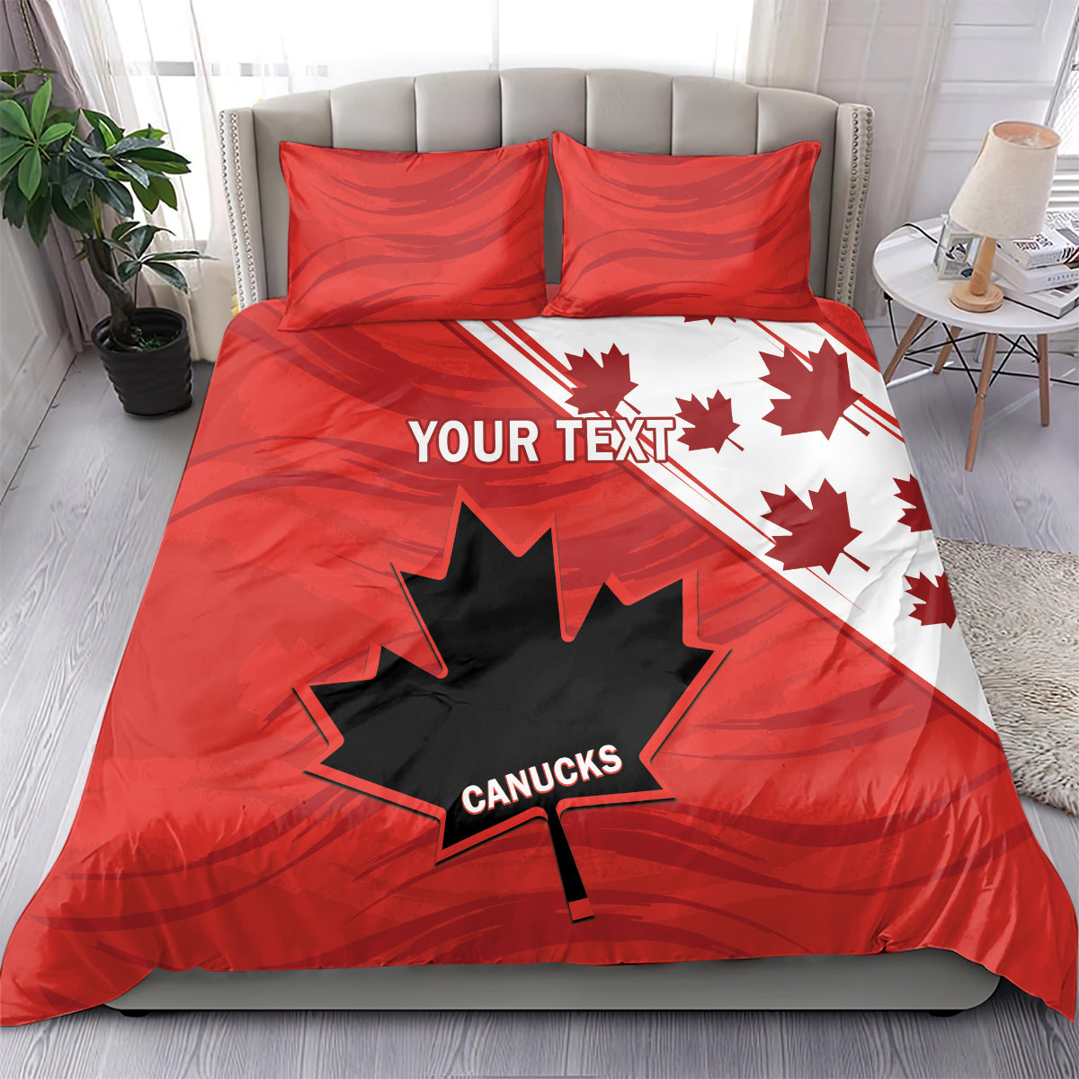 Red and white bedding set on bed with two pillow shams; maple leaf and star design.