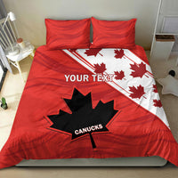 Red and white duvet cover with maple leaf and star graphic; two pillow shams on bed.