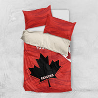 Red duvet cover with maple leaf and star graphic plus two pillow shams, folded.