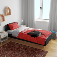 Red and black maple leaf star duvet set on bed with two red pillow shams.