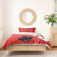 Red duvet cover with maple leaf and star graphic on bed; two pillow shams.