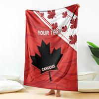 Red blanket with maple leaves and CANUCKS logo, hanging with bare feet visible