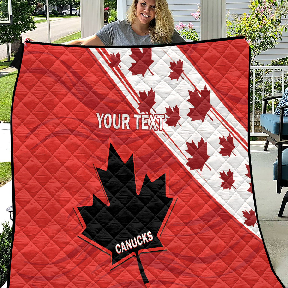 Red quilt with diagonal white Canada maples, black leaf-star, and 'YOUR TEXT' design