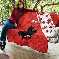 Red quilt with white maple pattern, black Canucks leaf-star logo, and 'YOUR TEXT'