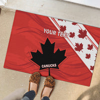 Red doormat with large black maple leaf, white Canadian leaf pattern, and 'CANUCKS'