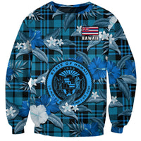 Blue sweatshirt with tropical floral print, black plaid, and Hawaii emblem on chest.