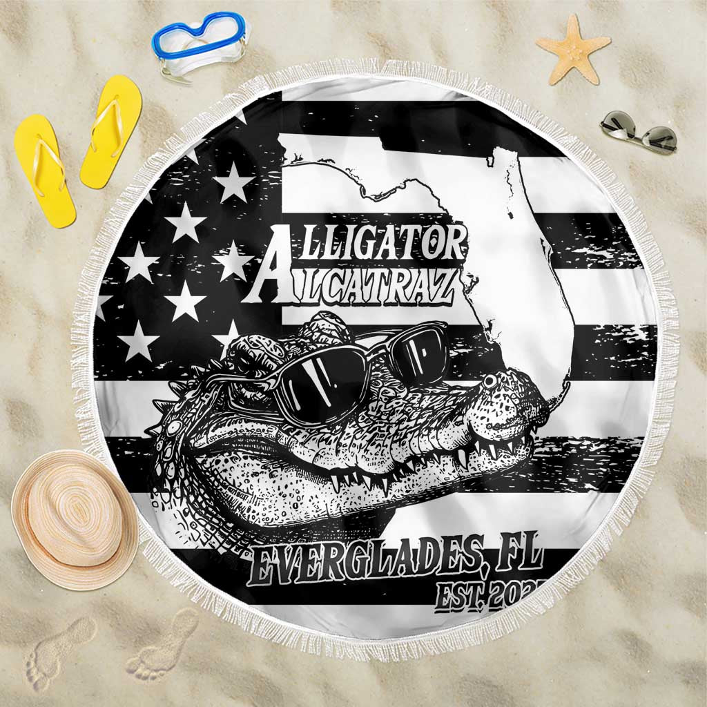 Round black-and-white beach blanket with fringed edge and alligator graphic design