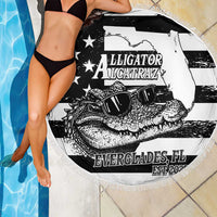 Round fringed beach blanket in black and white with alligator graphic, laid poolside