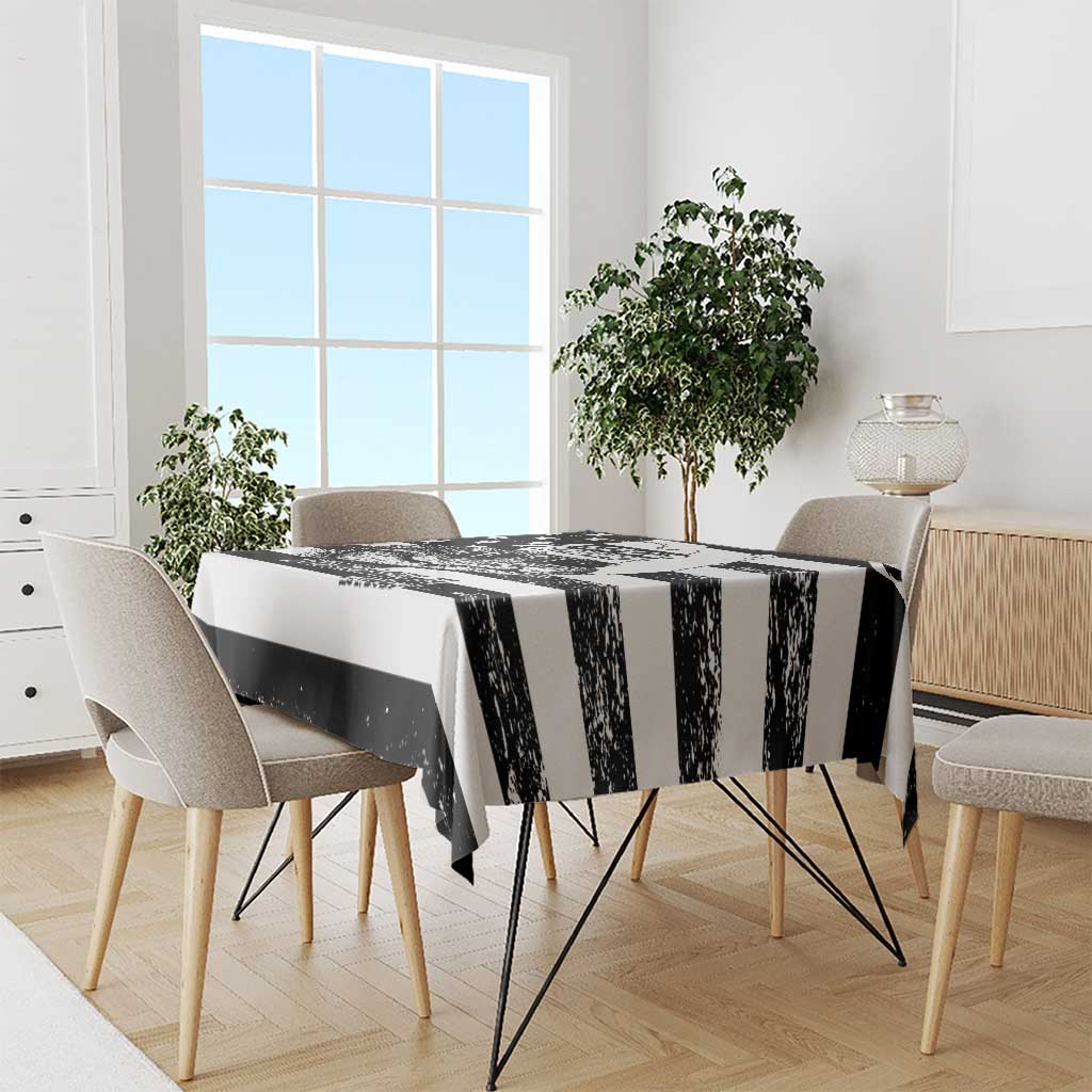 Black and white striped tablecloth draped over dining table with bold alligator motif
