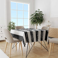 Black and white striped tablecloth draped over dining table with bold alligator motif