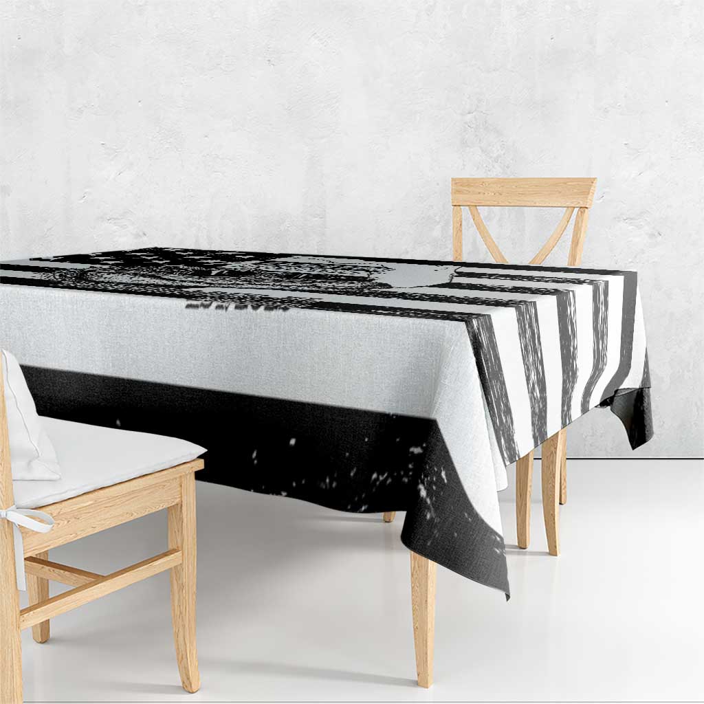 Black and white striped tablecloth with draped edge hanging over table corner