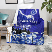 Blue eagle race blanket with Polynesian pattern and wave graphics, folded over a sofa with "YOUR TEXT"