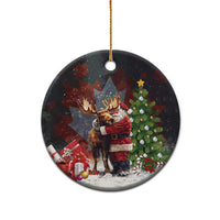 Black round ceramic Christmas ornament with gold string, Santa hugging a moose scene.