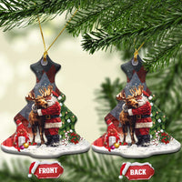 Black ceramic Christmas ornament shaped like a tree, Santa hugging a moose; front and back tags.