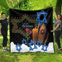Black quilt spread outdoors with blue Star of David, orange candlelight, red flower design