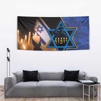 Blue camouflage memorial tapestry with Star of David and candle flames above a gray sofa