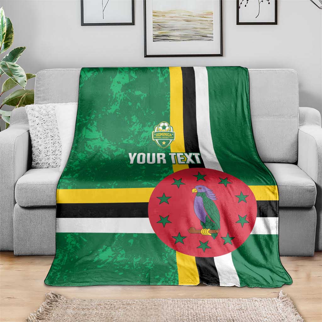 Green football blanket on sofa with Dominica flag stripes, bird emblem, red star circle, custom text
