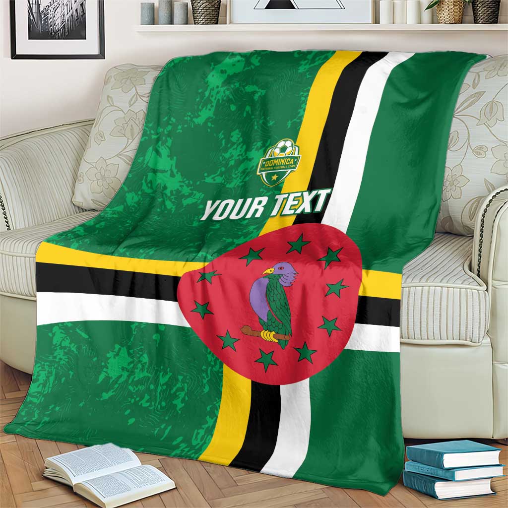 Green football blanket on sofa with Dominica flag stripes, bird emblem, red star circle, custom text