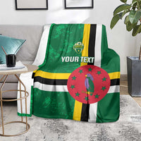 Green football blanket on couch with Dominica flag stripes, bird emblem in red circle, custom text