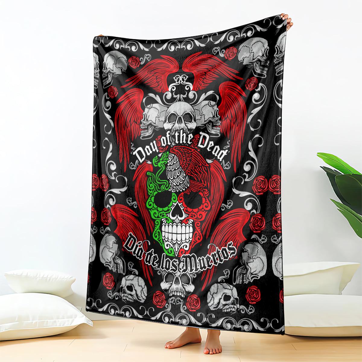 Day of the Dead blanket with central skull, red wings, green details, and roses on dark fabric