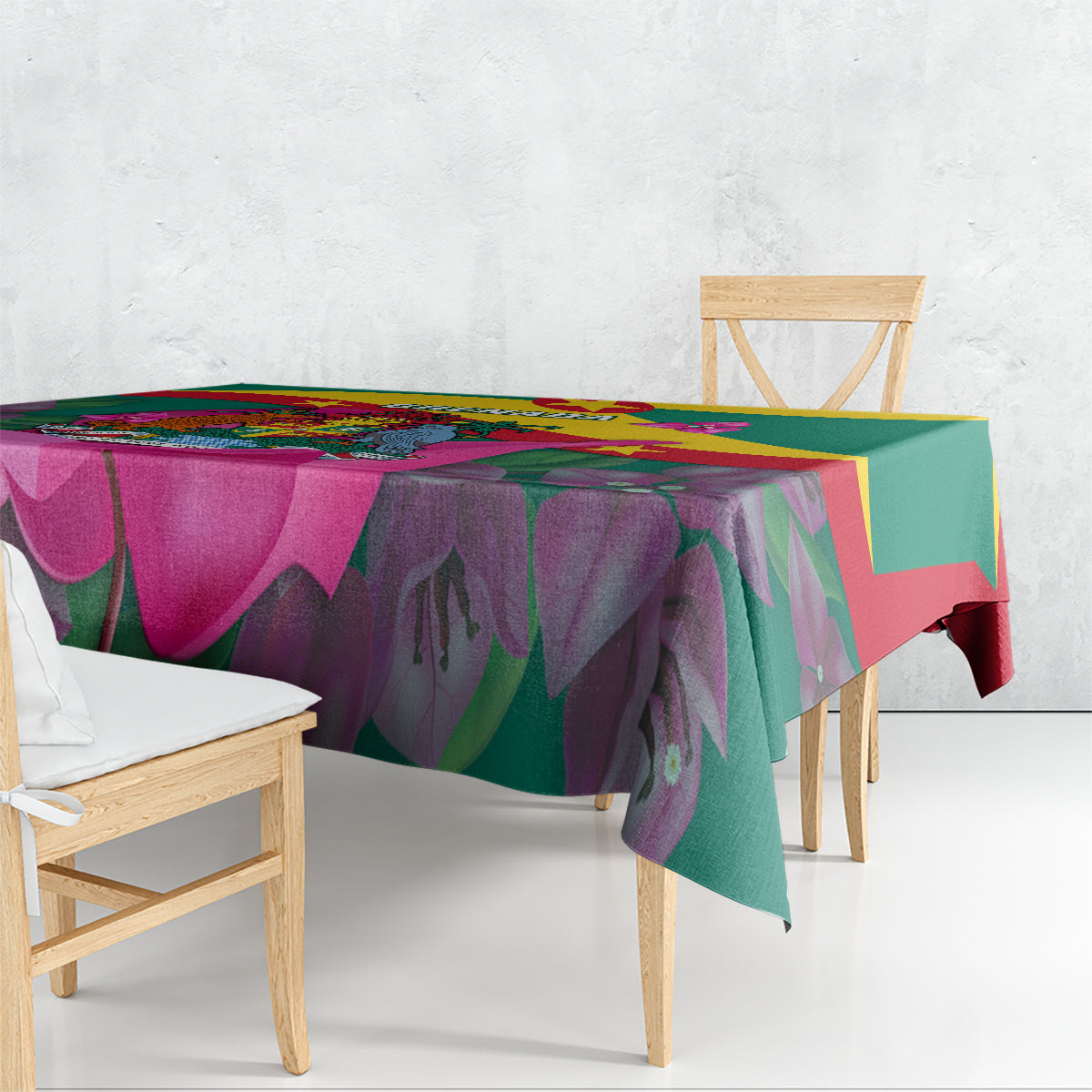 Green tablecloth draped on dining table with bougainvillea and Grenada flag print