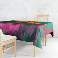Green tablecloth draped on dining table with bougainvillea and Grenada flag print