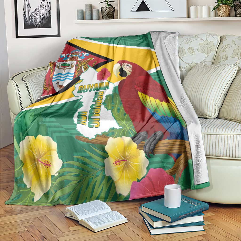 Guyana Republic Day blanket on couch, green flag artwork with scarlet macaw and large hibiscus blooms