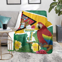 Guyana Republic Day blanket on floor chair, green flag stripes with scarlet macaw and hibiscus