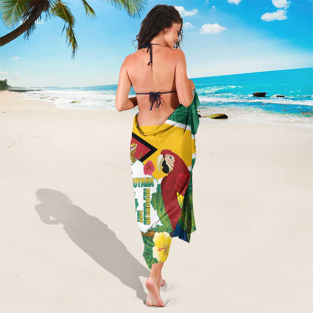 Green sarong scarf with Guyana flag motif, macaw graphic, and floral accents