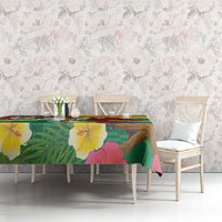 Tropical tablecloth in green with yellow trim, macaw, and map details on the fabric