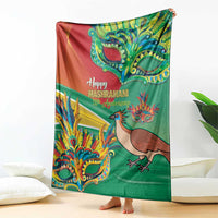 Green and red Mashramani anniversary blanket with bird and festive mask artwork, hanging