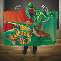 Hooded blanket draped over shoulders, featuring Happy Mashramani bird and mask art