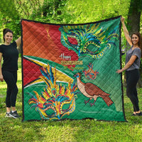 Green and red quilt showing colorful bird and mask artwork with “Happy Mashramani”