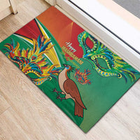 Green rubber doormat featuring bird, dragon, and festive greeting text